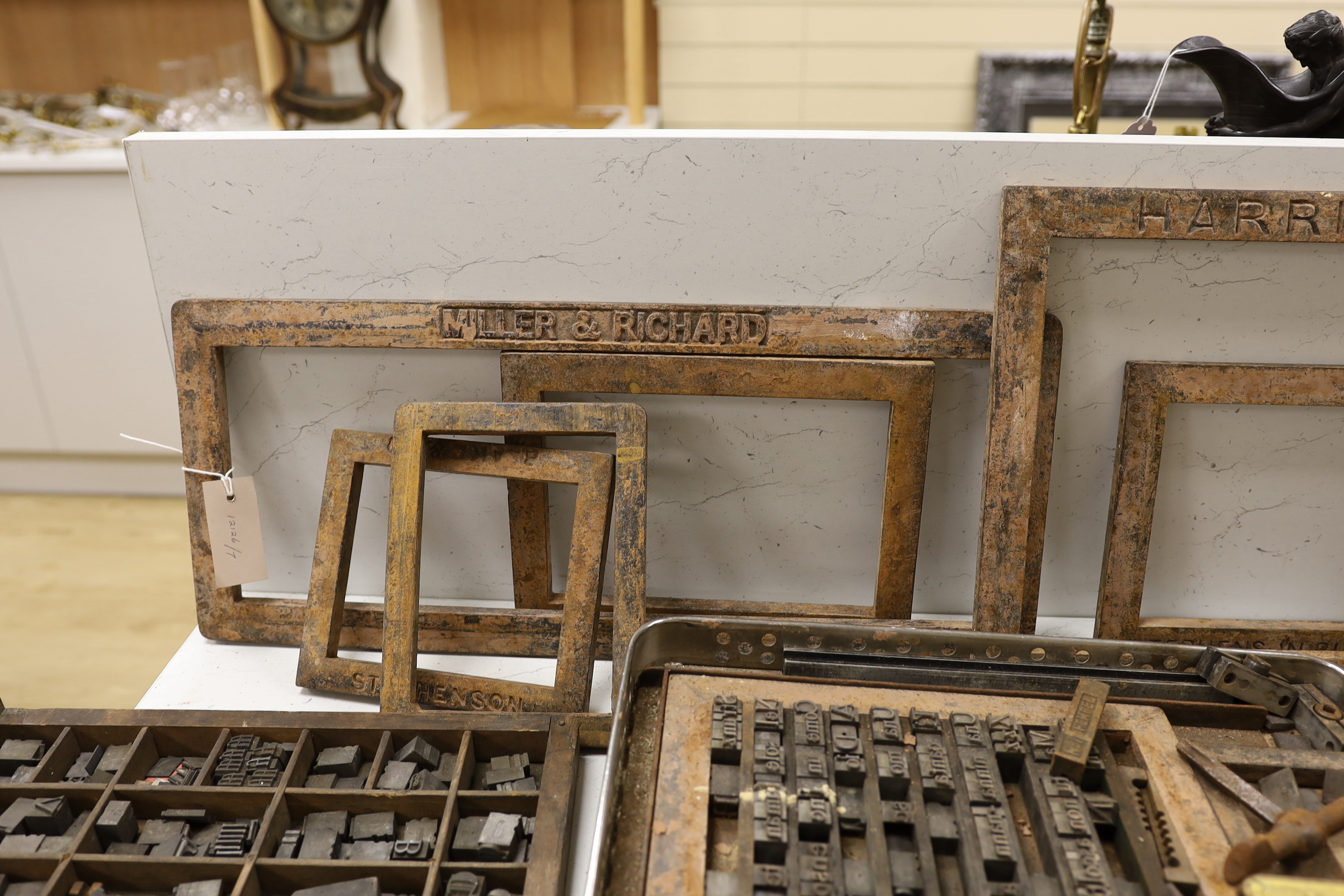 Three trays of metal printing type: chases, quoins and spacing bars